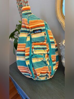 KAVU Rope Sling bag with vibrant multicolored stripe pattern and rope shoulder